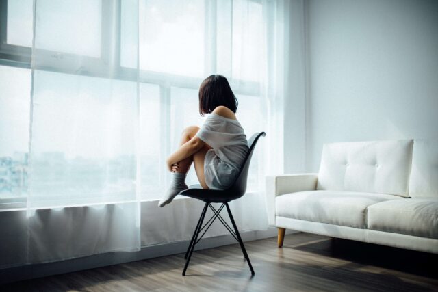 Girl sitting on chair looking out of the window